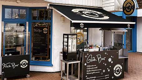 Außenansicht vom Ostseehappen Boltenhagen mit der Fisch.Bar und Glüh.Bar an der Mittelpromenade